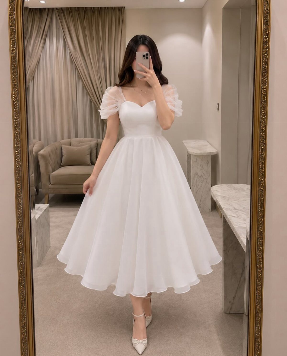 A woman posing in a white puff-sleeved midi dress and white heels.